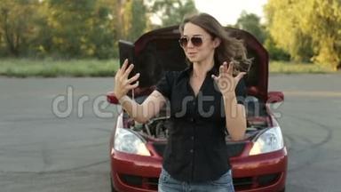 一个激动的女孩和一辆破车在路上。 给<strong>汽车服务</strong>部门打电话